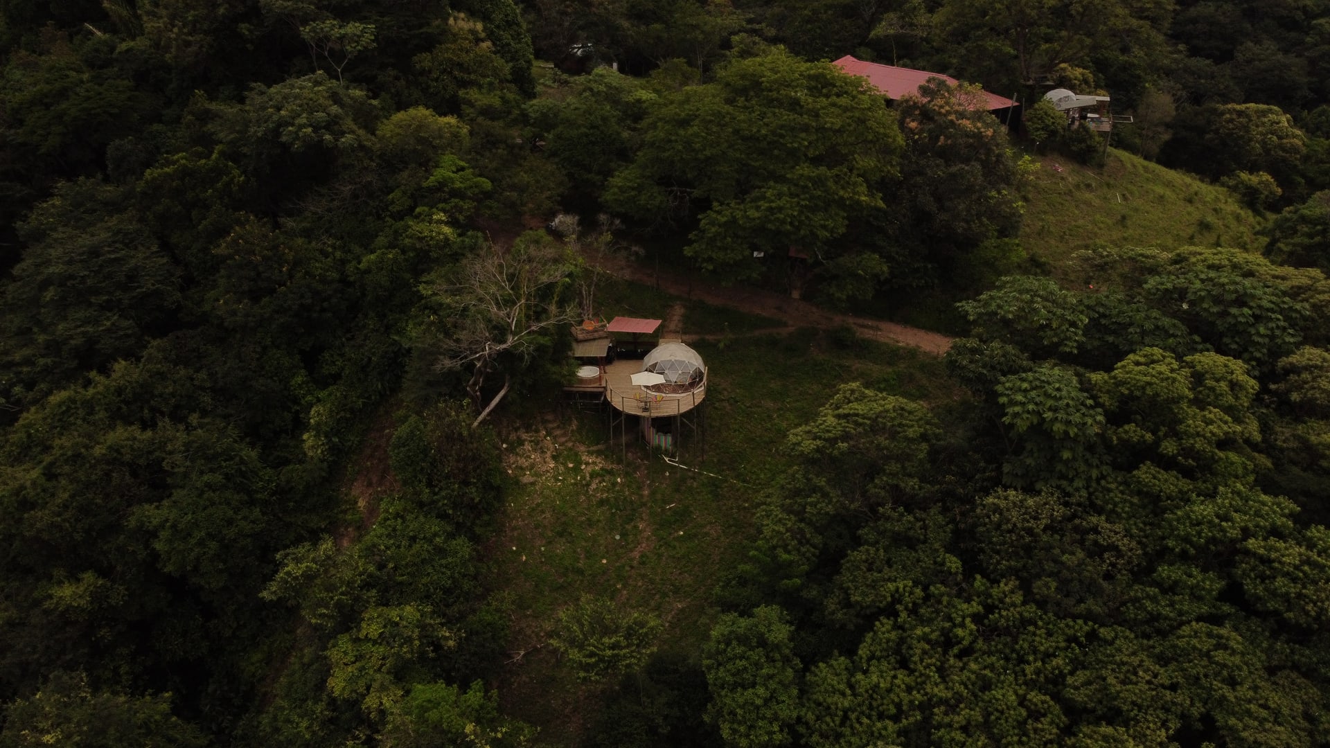 Vista aérea del ecoparque, con el domo y las cabañas entre el bosque.